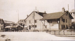 Station du chemin de fer de Renens de 1855 à 1908. Jusqu'en 1888, le bureau du chef de gare et la salle d'attente se trouvaient dans le baraquement, sous la passerelle. (Source J.-C. Marendaz)